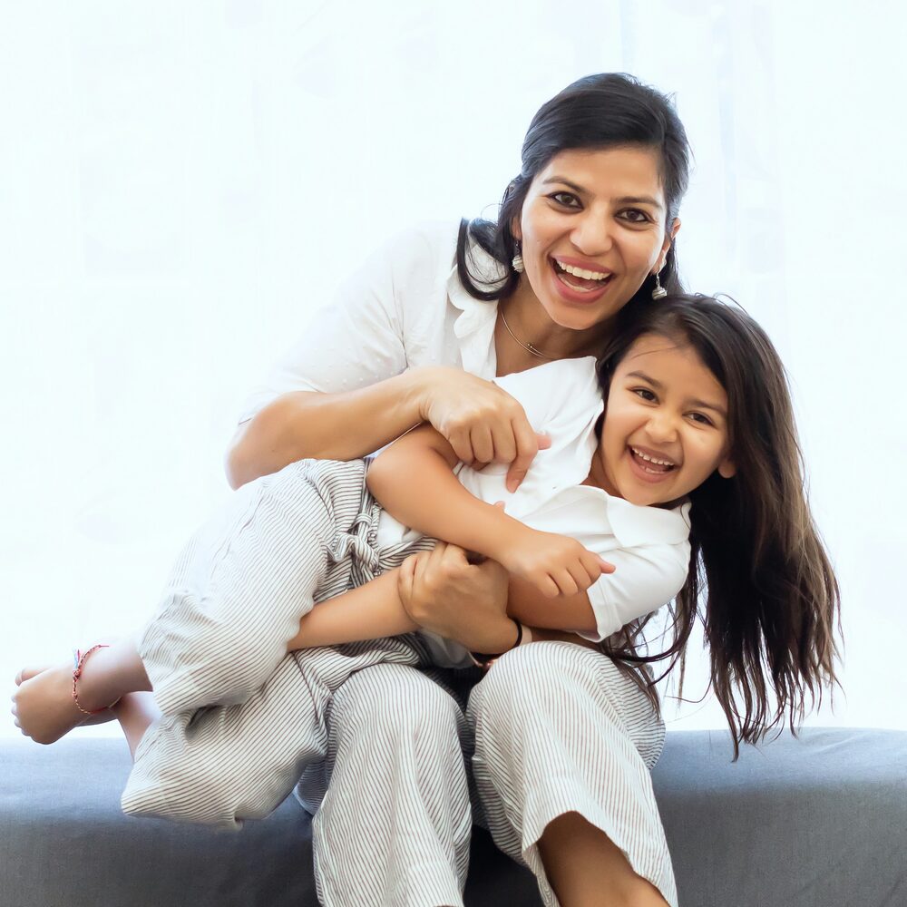 A mother laughing with her young daughter